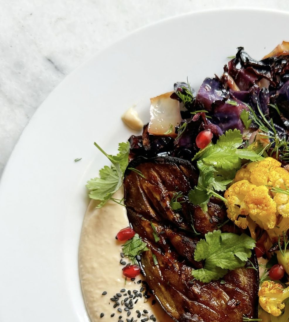 Geschmorte Aubergine auf Hummus mit Blumenkohl und Kräutern